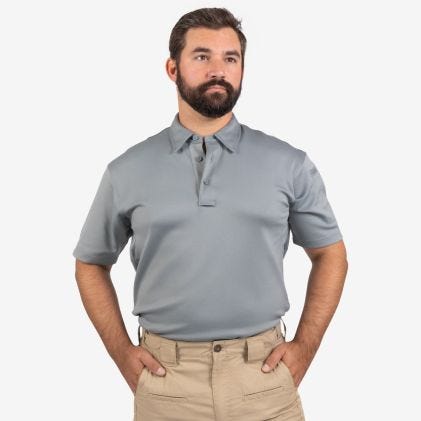 Man wearing a gray polo shirt and beige pants on a white background