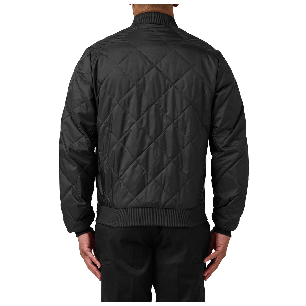 Black quilted jacket worn by a person on a white background