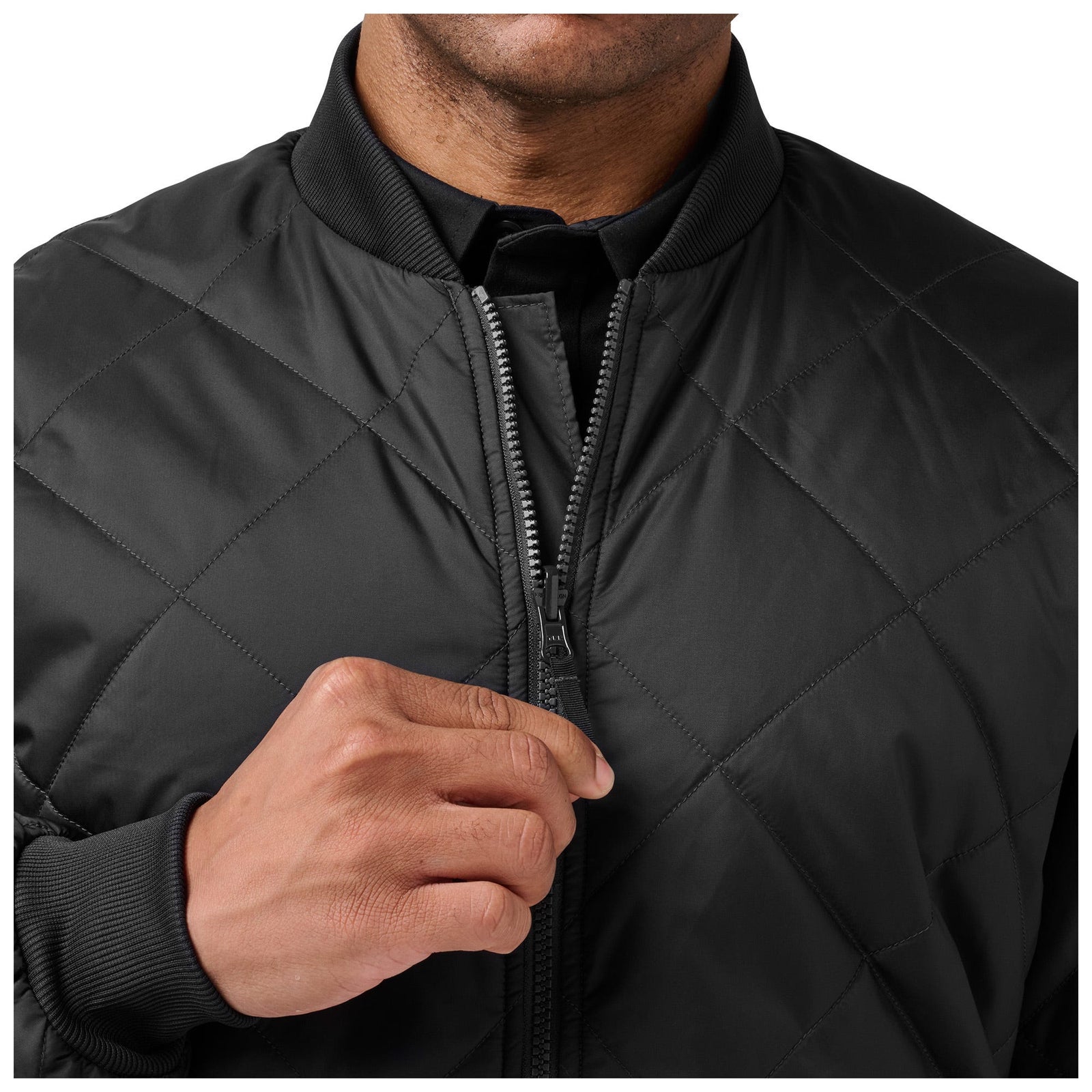Black quilted jacket with a person adjusting the zipper on a white background