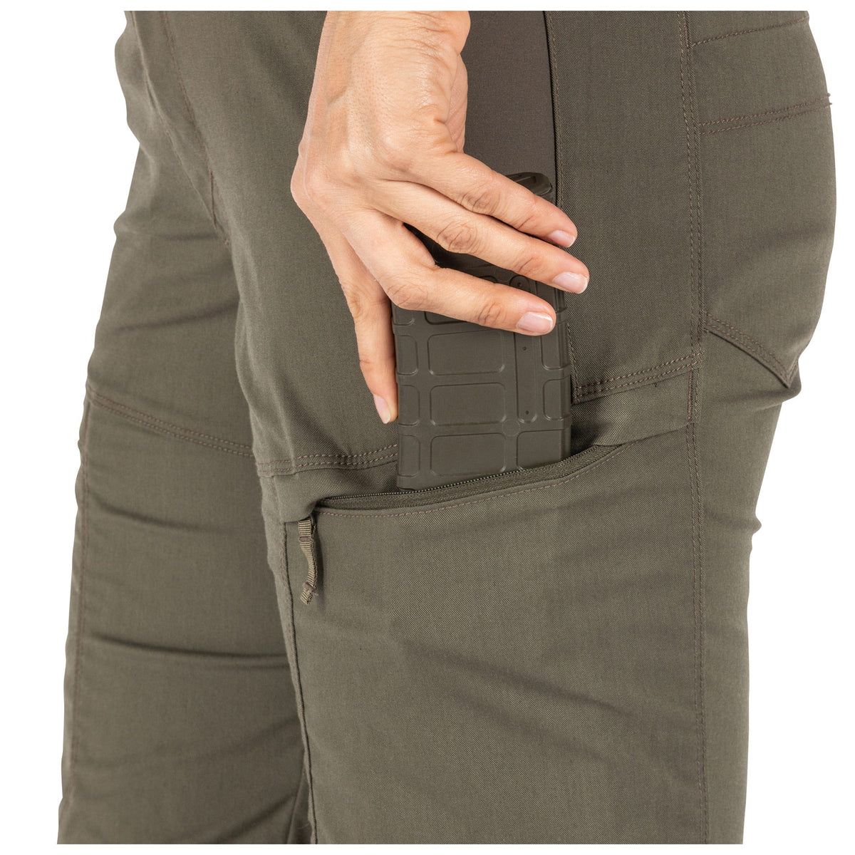 Close-up of a person wearing olive green pants with a pocket detail.