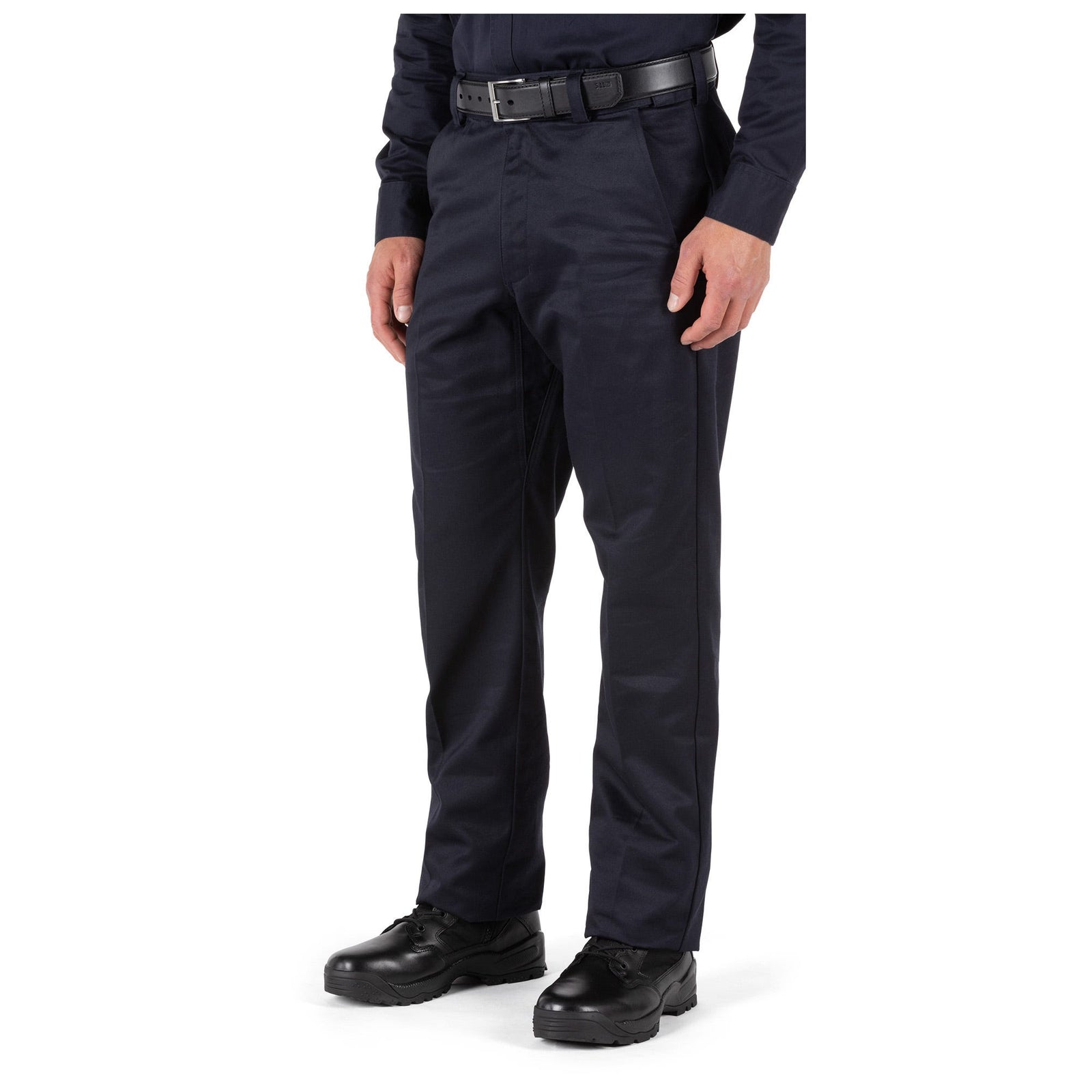 Person wearing dark blue pants and black shoes on a white background
