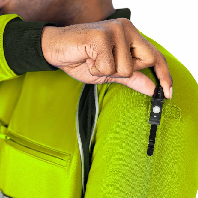 Person wearing a bright green jacket with a close-up of a hand adjusting a zipper.