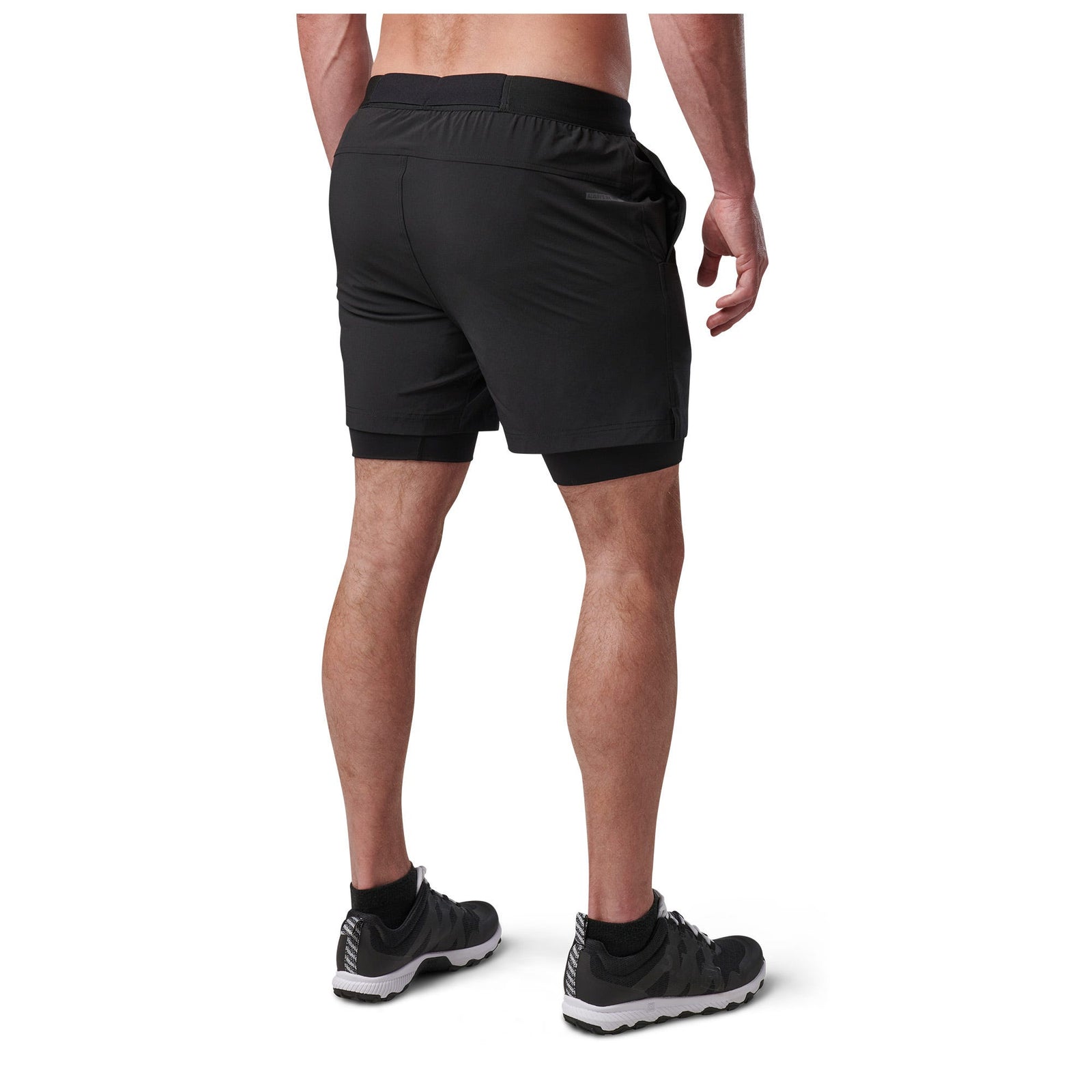 Person wearing black athletic shorts on a white background