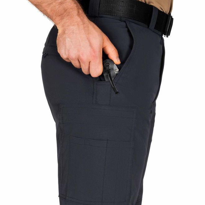 Person wearing dark pants with a pocket holding a gun, on a white background