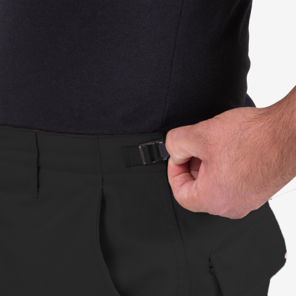 Close-up of a person adjusting the waistband of black pants on a white background
