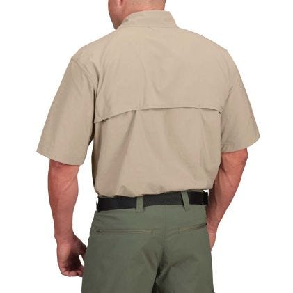Person wearing a beige shirt and green pants on a white background
