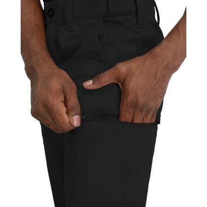 Close-up of black pants with a person's hands in the pockets on a white background