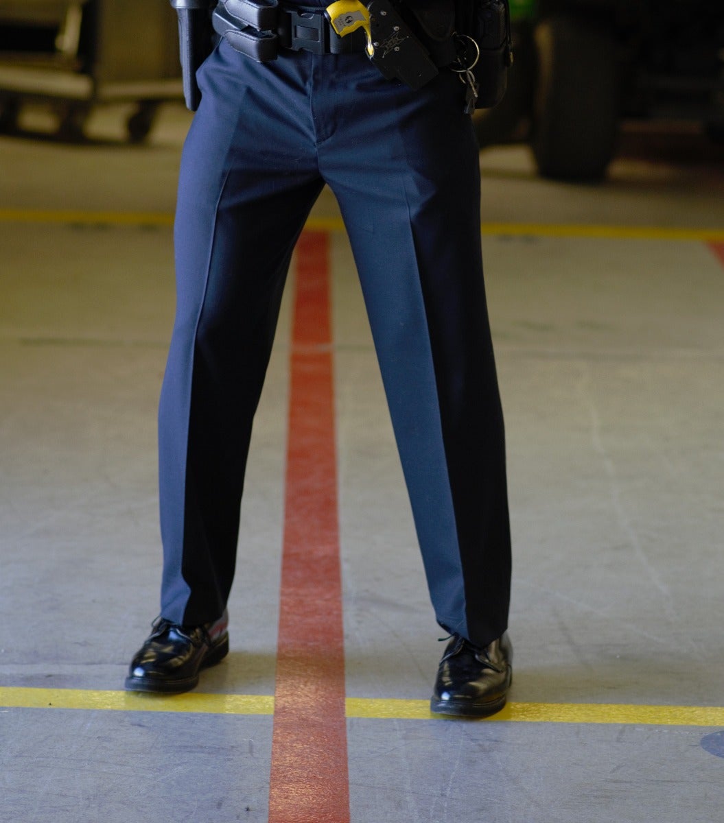 Person wearing blue pants and black shoes standing on a floor with red and yellow lines.
