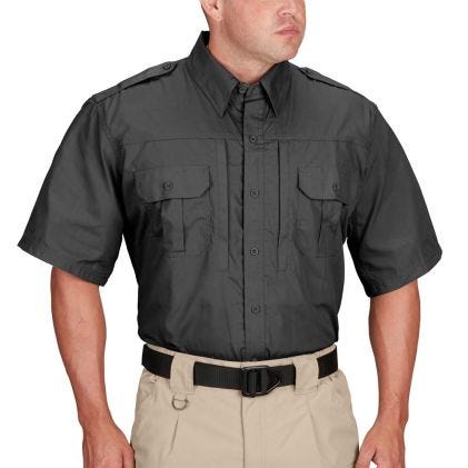 Person wearing a black short-sleeve shirt with pockets on a white background