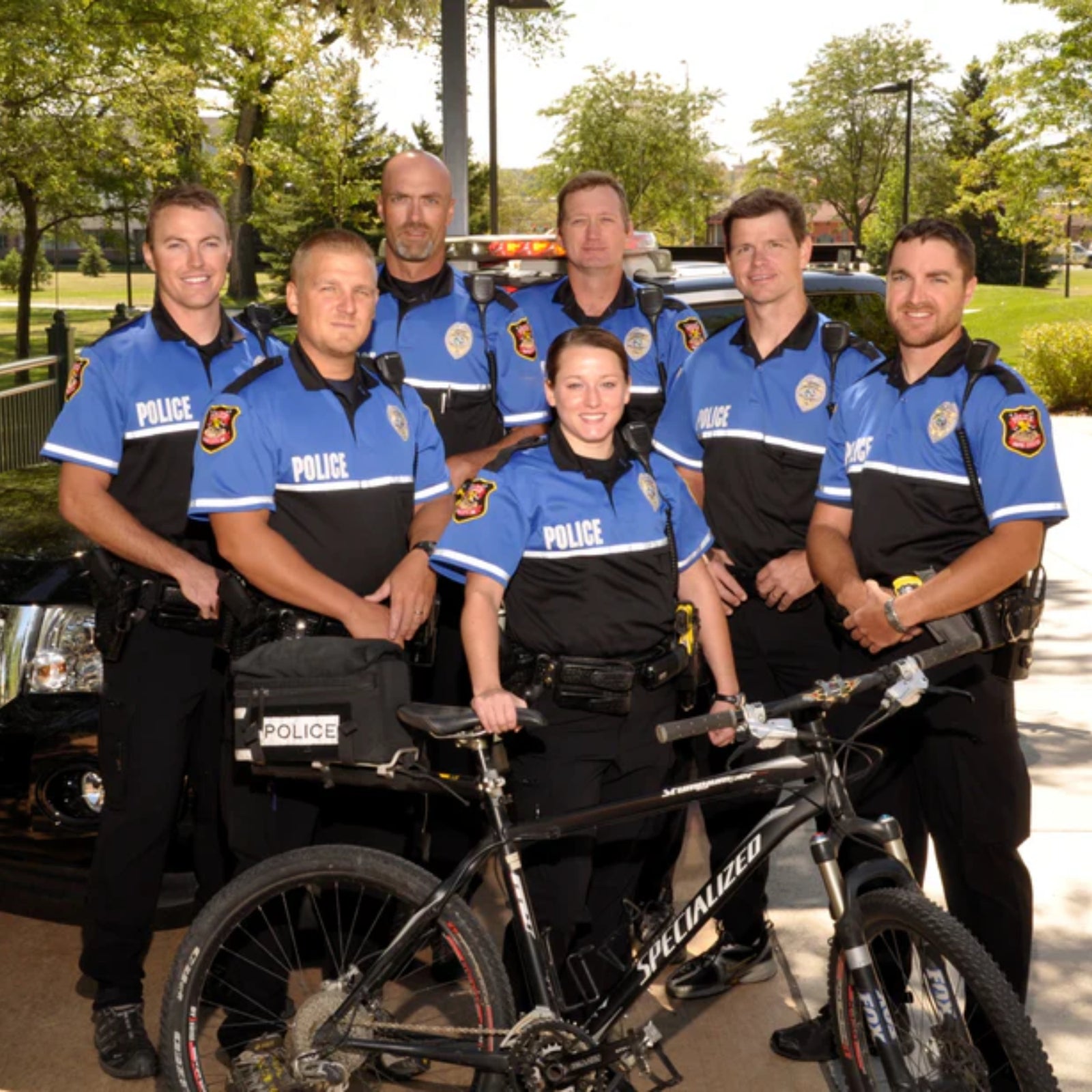 Group of police officers with a bicycle in an outdoor setting