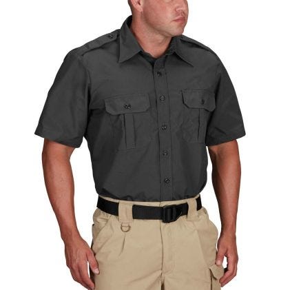 Man wearing a dark gray short-sleeve shirt and beige pants on a white background