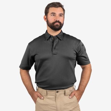 Man wearing a black polo shirt and beige pants on a white background