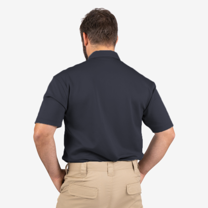 Man wearing a navy polo shirt and beige pants on a white background
