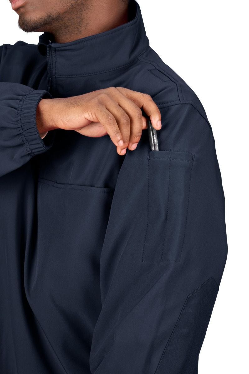Person wearing a navy blue jacket with a close-up of a pocket.