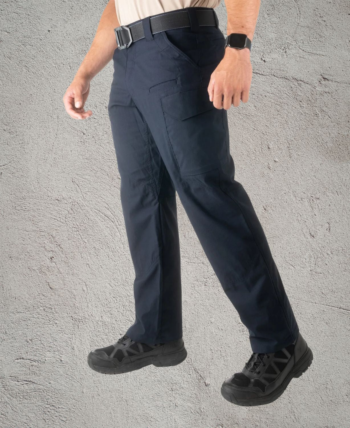 Person wearing navy blue pants on a gray background