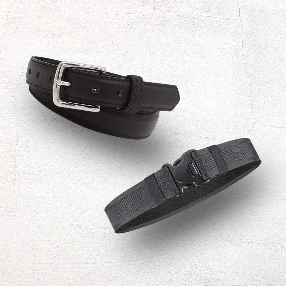 Two black belts with silver buckles on a beige background