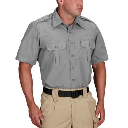 Man wearing a gray short-sleeve shirt with pockets and beige pants on a white background