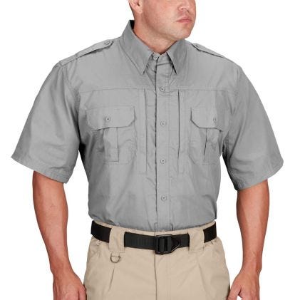 Person wearing a gray short-sleeve shirt with pockets and khaki pants on a white background