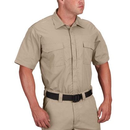 Man wearing a beige short-sleeve shirt and pants on a white background
