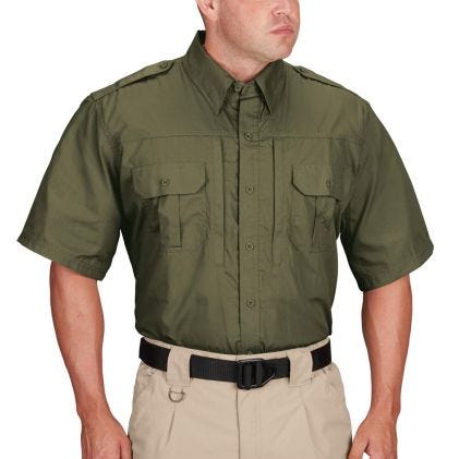 Person wearing an olive green short-sleeve shirt and beige pants on a white background
