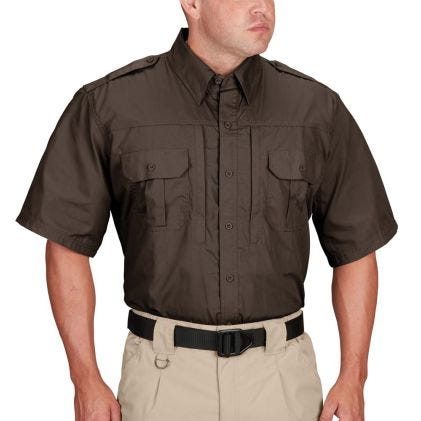 Man wearing a brown short-sleeve shirt and beige pants on a white background
